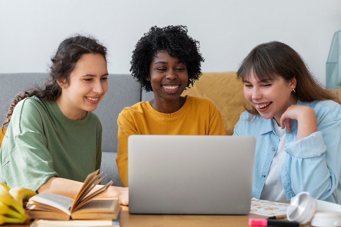 Students collaborating enthusiastically on a laptop